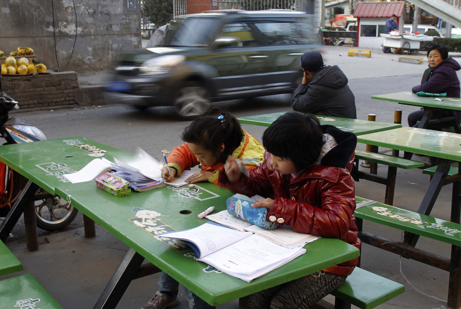 two girls are doing their homework in front of a supermarket