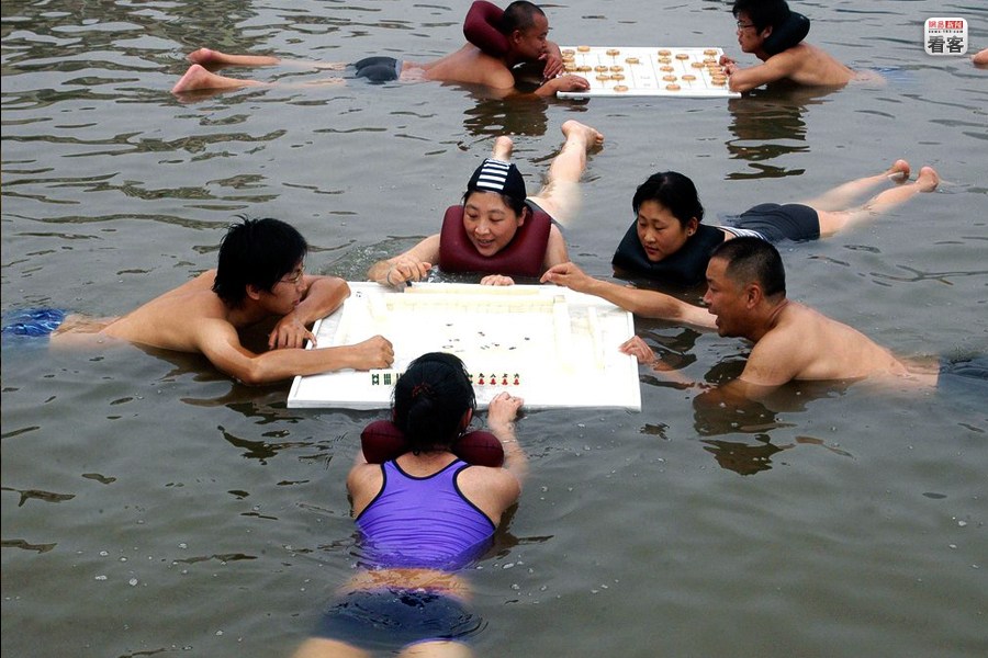 wet play,  A group of Mahjong fans are playing Mahjong in a water park. 