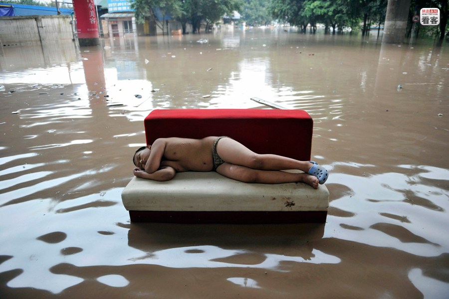 A boy is sleeping on a sofa after a flood in Chongqing