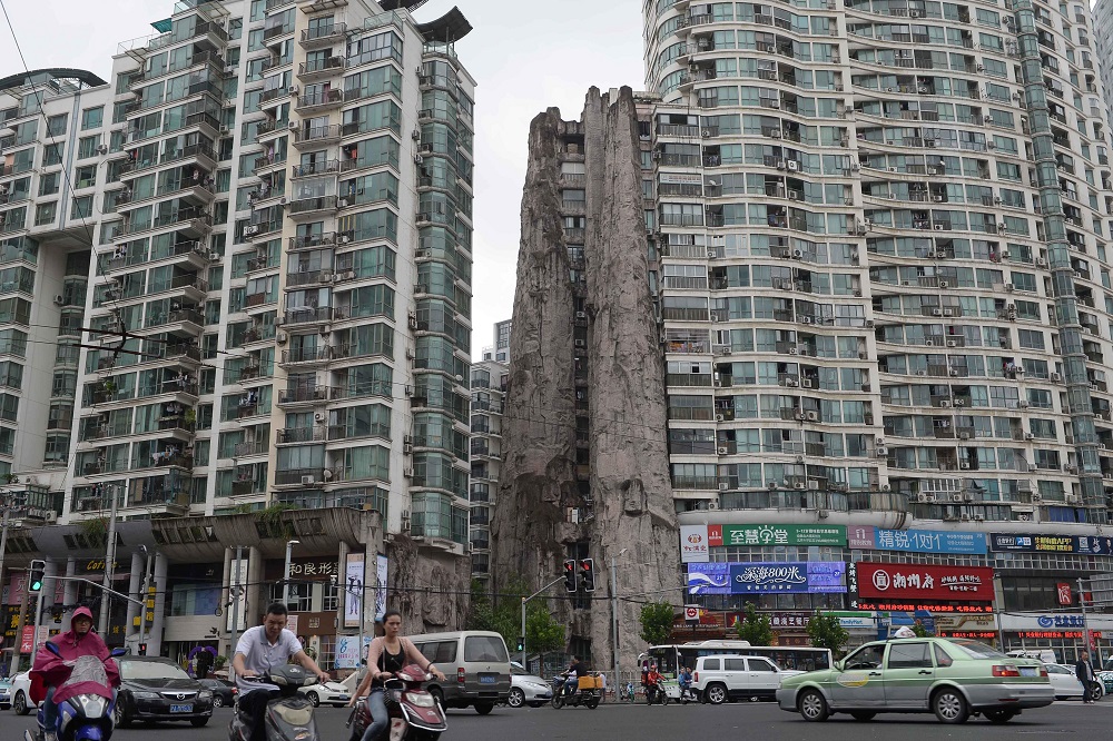 A building in Shanghai that has been partly  wrapped with a fake concrete mountain